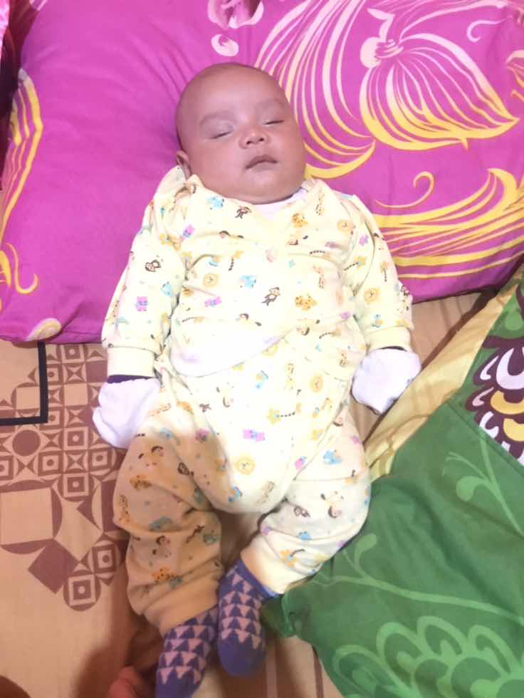 Anak sebulan tidur dengan bantal dewasa