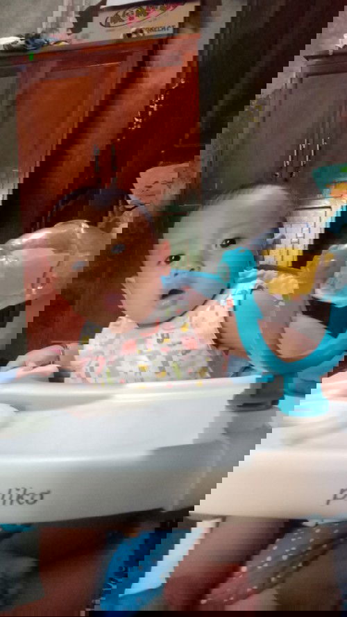 Makan sambil duduk di kursi makan.