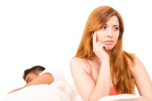 Young depressed couple in bed - daylife problems concept