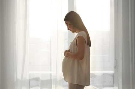 isang buntis na babae na hinahawakan ang kaniyang tiyan - normal na pag galaw ni baby sa tiyan