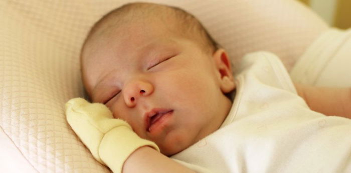 How does wearing baby mittens affects babies development?