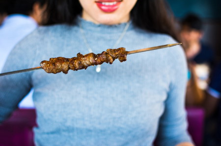 asian woman eating barbeque