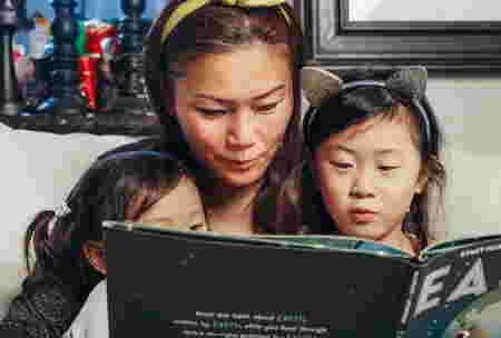 mom reading book with her children