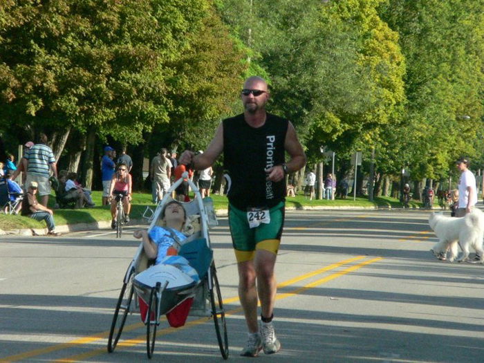 Dad runs race carrying disabled daughter