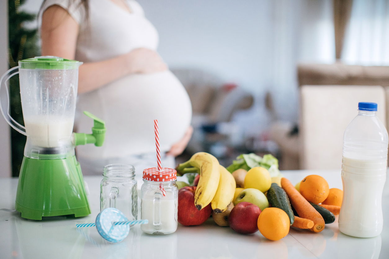 pregnant woman making a smoothie
