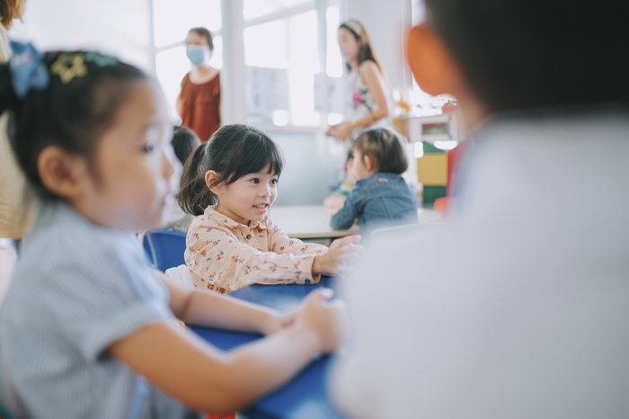Primary school child working through Kumon worksheets at a table