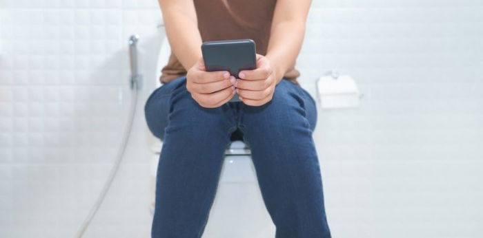 Hati-hati, main ponsel saat BAB bisa tingkatkan risiko ambeien!
